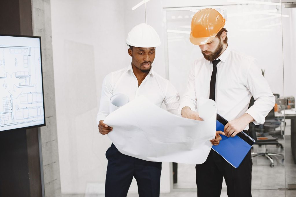 Architects in hard hats reviewing project plans